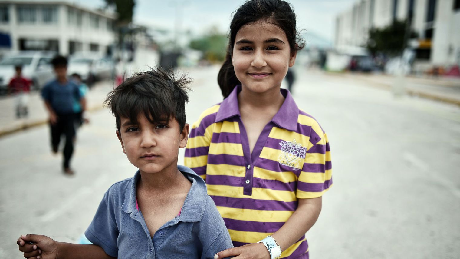 Des enfants portant un bracelet d'identificaton dans un camp pour migrants à l'ancien aéroport d'Athènes le 13 juin 2016 afp.com/LOUISA GOULIAMAKI