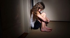 photo d'une enfant prostrée dans le couloir d'une maison