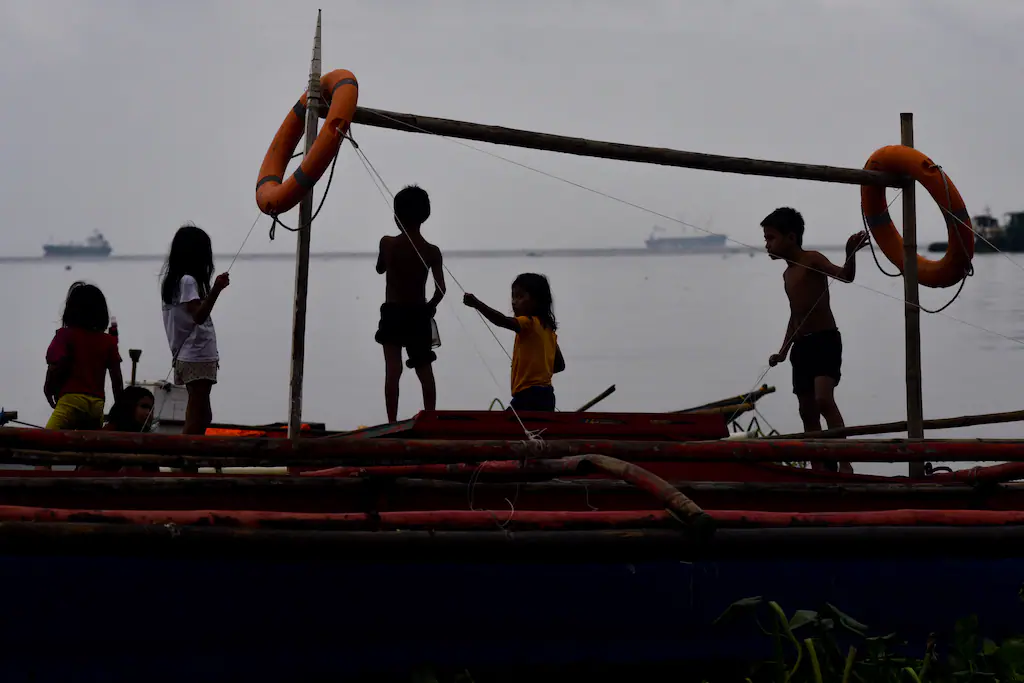 En 2019, aux Philippines, dans un bidonville bordant la baie de Manille très polluée. (George Calvelo/AFP)
